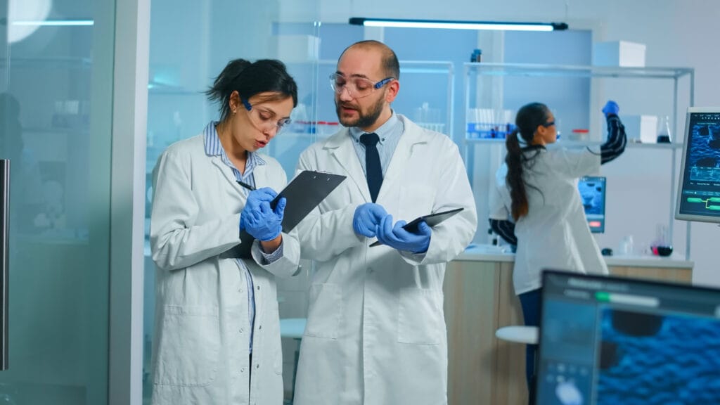 Oportunidade Real: Como Médicos Brasileiros Podem Se Posicionar para Projetos Europeus de Saúde 3 Médicos analisando amostras de pesquisa