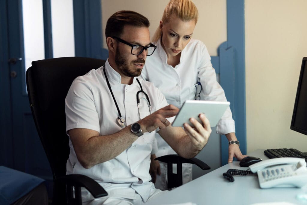 Equipe médica com tablet discutindo dados Horizonte Europa para médicos em Portugal