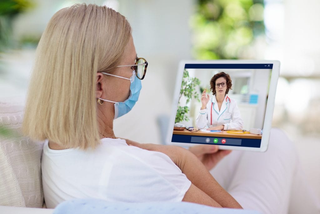 Paciente em Portugal em teleconsulta por tablet com uma médica — telemedicina para Portugal a partir do Brasil