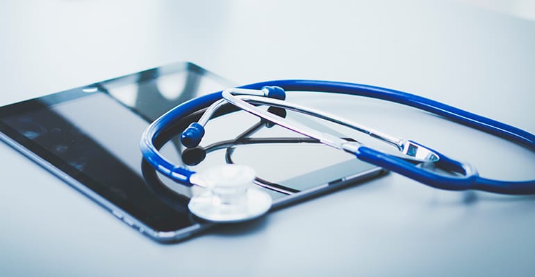 Estetoscópio sobre um tablet, símbolo da telemedicina para Portugal a partir do Brasil