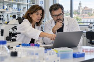 Dois pesquisadores analisam dados em um laboratório biomédico.
