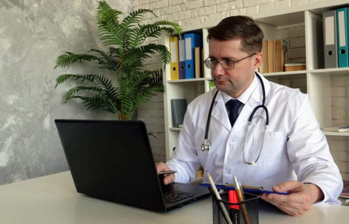 Telemedicine concept. A Doctor works with laptop.